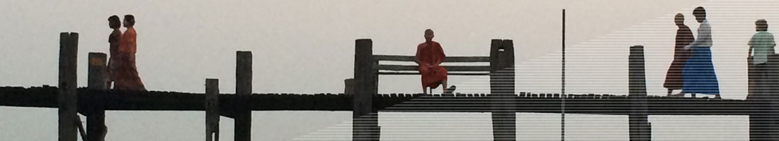 Menschen auf einer langen Holzbrücke im Abendlicht